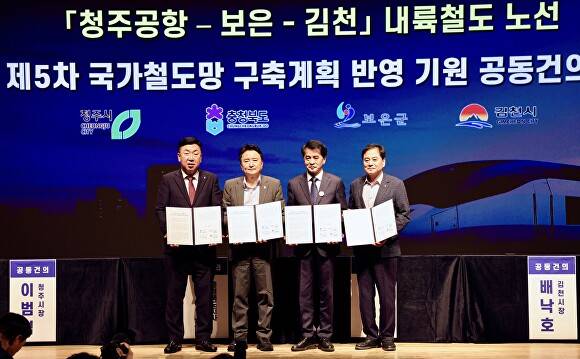 4개 지자체장들이 3일 보은문화예술회관에서 5차 국가철도망 구축 계획에 청주공항~보은~김천 내륙철도 노선 반영을 요구하는 공동건의문에 서명한 뒤 기념 촬영을 하고 있다. [사진=보은군]