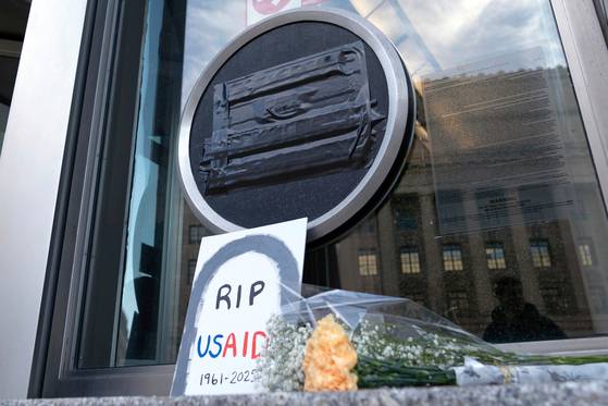 지난 2월 미국 워싱턴 국제개발처(USAID) 본부 앞에서 시위대들이 USAID 폐지에 항의하기 위해 'USAID 편히 잠드길' 이란 문구와 근조 화환을 본부 문 앞에 놨다. AP=연합뉴스
