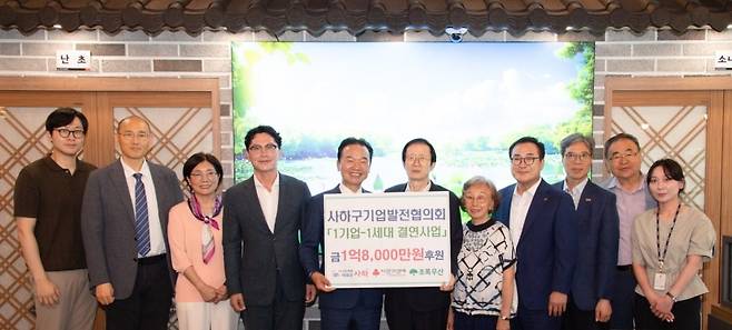 이갑준 사하구청장(사진 왼쪽 여섯번째)과 최금식 사하구기업발전협의회 회장(사진 왼쪽 다섯번째)이 지난 2일 열린  1기업-1세대 결연사업 후원금 전달식에서 기념촬영하고 있다. [사하구 제공]