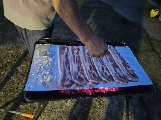 [서울=뉴시스] 송종호 기자= 3일 식품안전정보워에 따르면 알루미늄 호일은 알루미늄 합금을 얇게 압연해 만든 제품으로, 이를 음식의 조리나 보관에 사용하면서 섭취되는 알루미늄의 양은 인체에 해를 끼치지 않는 수준인 것으로 알려져 있다. 사진은 야외에서 알루미늄 호일 위에 고기를 굽는 모습. 2025.07.02. song@newsis.com *재판매 및 DB 금지