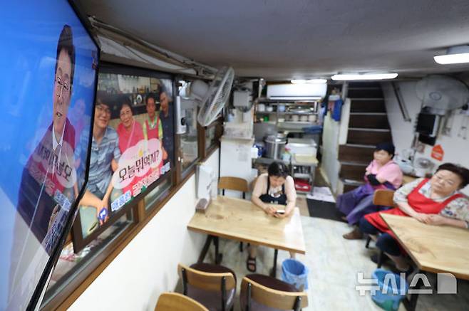 [서울=뉴시스] 권창회 기자 = 3일 서울 중구 남대문시장 내 식당에 이재명 대통령 취임 30일 기자회견 '대통령의 30일, 언론이 묻고 국민에게 답하다'가 생중계되고 있다. 2025.07.03. kch0523@newsis.com