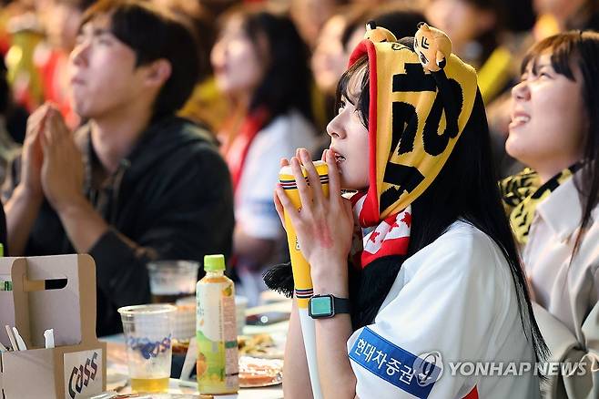 간절한 마음 (광주=연합뉴스) 천정인 기자 = 한국시리즈 5차전 경기가 열린 28일 광주 서구 김대중컨벤션센터 앞에서 야구팬들이 중계를 지켜보고 있다. 2024.10.28 iny@yna.co.kr