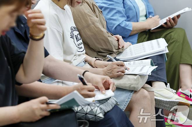 8일 오후 서울 성북구 강북종로학원에서 열린 '6월 모평 토대 합격점수 예측 및 2026 수시·정시 지원전략 특집설명회'를 찾은 수험생 학부모들이 입시분석 자료를 살펴보고 있다. 2025.6.8/뉴스1 ⓒ News1 민경석 기자