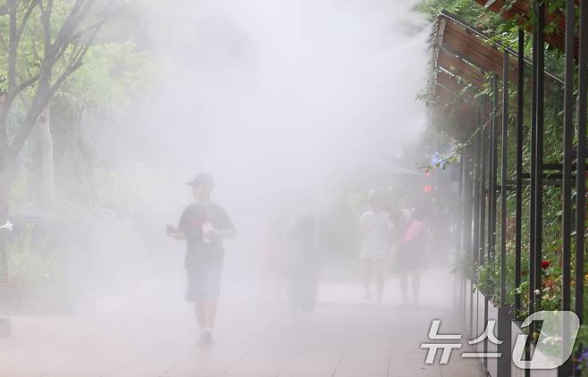 무더위가 이어지는 3일 오후 시민들이 서울광장에 설치된 쿨링포그 앞을 지나며 더위를 식히고 있다. 2025.7.3/뉴스1 ⓒ News1 구윤성 기자