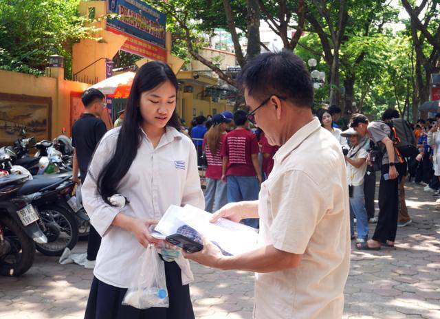 지난달 26일 베트남 하노이에서 한 아버지가 전국 고교 졸업 시험을 치르는 딸이 고사장에 입실하기 전 물품을 다시 확인하고 있다. 하노이=허경주 특파원