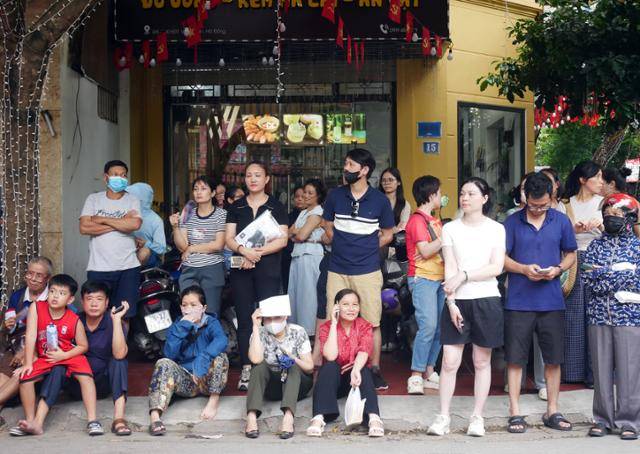베트남 전국 고등학교 졸업 시험 첫날인 지난달 26일 하노이의 한 고사장 앞에서 수험생 학부모들이 자녀가 시험을 마치고 나오기를 기다리고 있다. 하노이=허경주 특파원