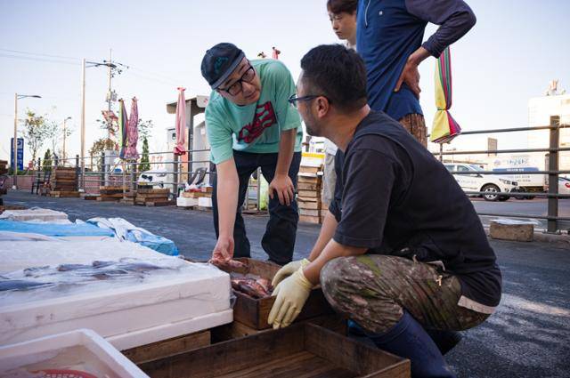김현기 '실비바 파도' 대표가 경남 마산어시장에서 중매인, 상인들과 물건을 살피고 있다. 장준우 제공