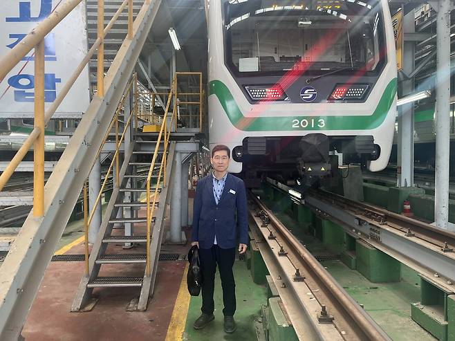 군자차량사업소에서 서울 지하철 2호선 열차를 배경으로 김성관 씨가 포즈를 취하고 있다. 박병국 기자