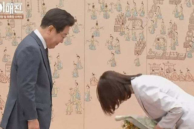 이재명 대통령으로부터 꽃다발을 받은 김민석 국무총리 부인 이태린 여사가 허리 숙여 인사하고 있다. KTV 이매진 캡처