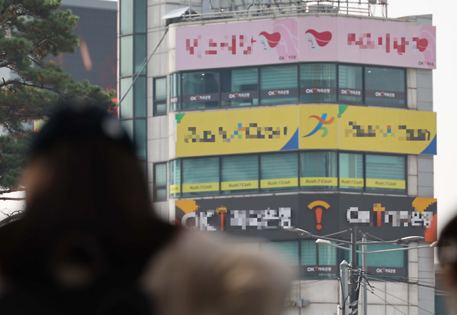 서울역 인근 상가에 밀집한 대부업체 간판 아래로 한 시민이 지나가고 있다. [한주형 기자]