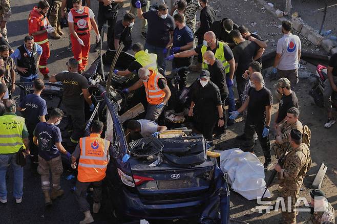 [할데=AP/뉴시스] 3일(현지 시간) 레바논 베이루트 남부 할데에서 민방위대원들이 이스라엘 드론 공습으로 파괴된 자동차에 있는 희생자 시신을 수습하고 있다. 2025.07.04