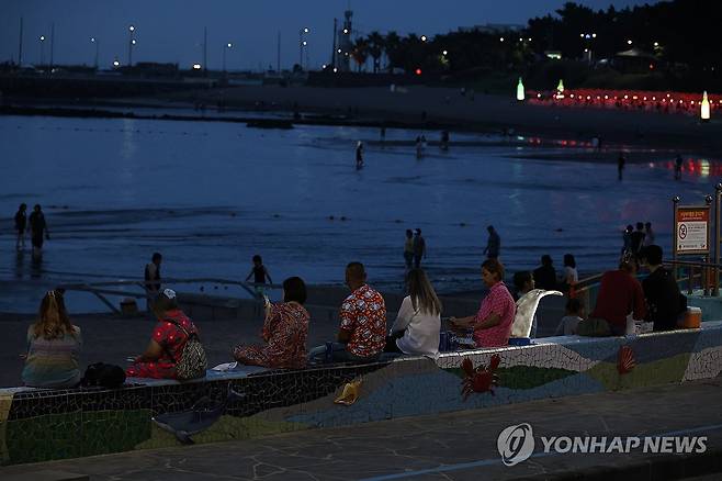 밤에도 식지 않는 더위 (제주=연합뉴스) 백나용 기자 = 산지와 추자도를 제외한 제주도 전역에 폭염특보가 발효 중인 1일 오후 제주시 이호테우해수욕장을 찾은 도민과 관광객이 바닷물에 발을 담그며 무더위를 식히고 있다. 2025.7.1 dragon.me@yna.co.kr
