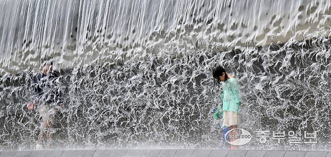 전국 대부분 지역에 폭염 특보가 내려진 6일 오후 수원시 영통구 광교호수공원 신비한 물너미에서 한 아이가 시원한 낙수를 맞으며 더위를 식히고 있다. 김경민기자