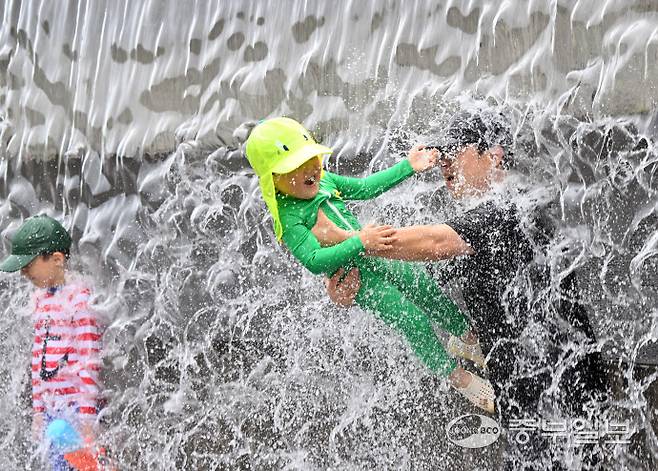 전국 대부분 지역에 폭염 특보가 내려진 6일 오후 수원시 영통구 광교호수공원 신비한 물너미에서 가족들이 시원한 낙수를 맞으며 더위를 식히고 있다. 김경민기자