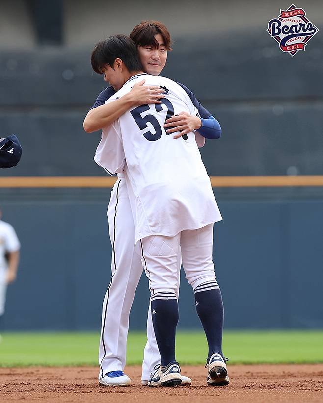 김재호(왼쪽)가 6일 열린 KBO리그 잠실 KT 위즈-두산 베어스전에서 1회초 교체 투입된 박준순에게 유니폼 상의를 건넨 뒤 포옹하고 있다. (두산 베어스 제공)