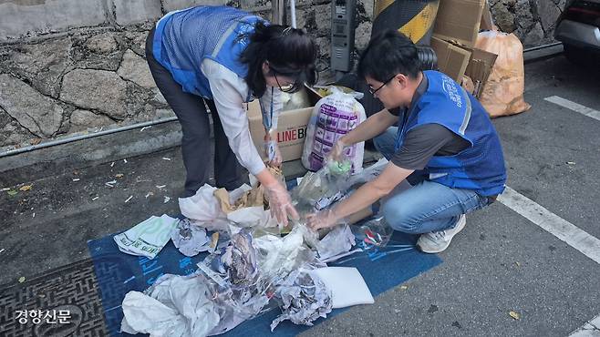 서울 강남구청 소속 쓰레기무단투기 단속원들이 지난 3일 저녁 폐비닐 수거봉투를 열어 부적합 쓰레기를 구분하고 있다.