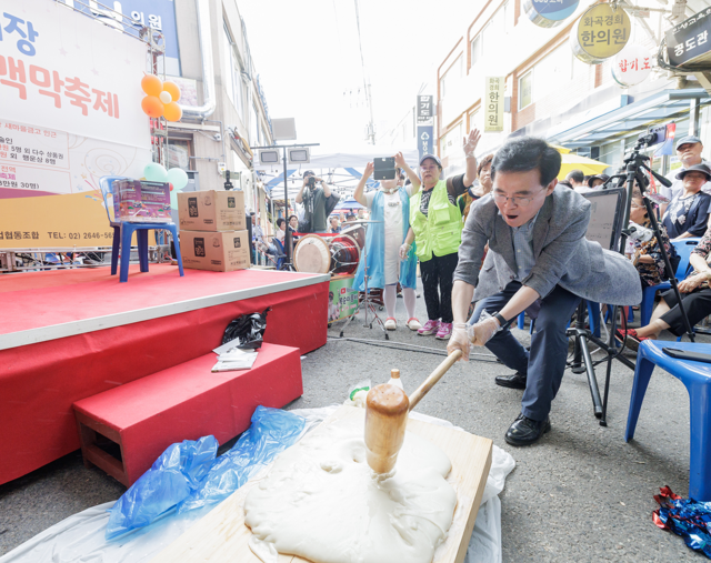 진교훈 서울 강서구청장이 화곡동 남부골목시장에서 열린 ‘맥(주)막(걸리)축제’에서 떡매치기 체험을 하고 있다. 강서구청 제공