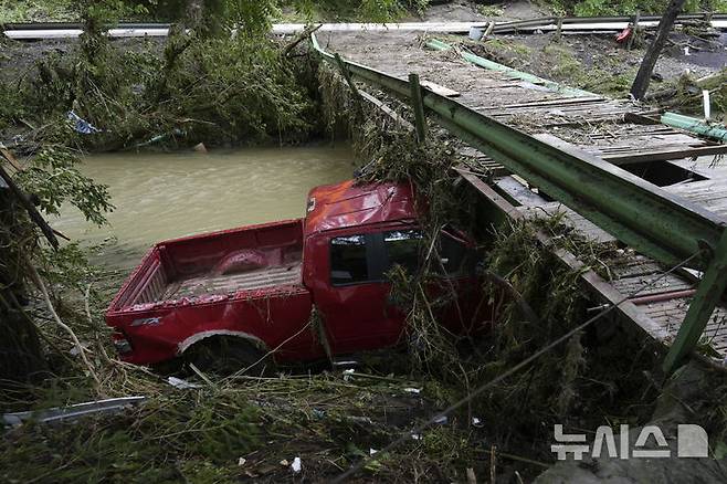 [밸리 그로브=AP/뉴시스] 지난 6월16일 미 웨스트버지니아주 밸리 그로브에서 홍수에 떠내려가던 픽업 트럭 한 대가 교량에 박혀 멈춰 서 있다. 돌발홍수도 토네이도처럼 실시간 경보가 필요하다고 미 당국은 말하고 있다. 2025.07.06.