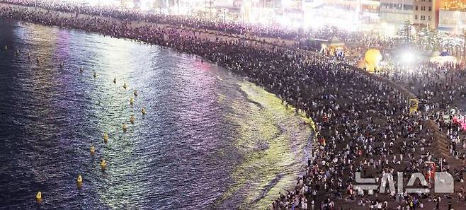 [부산=뉴시스] 하경민 기자 = 폭염특보와 열대야 현상으로 인해 밤낮으로 푹푹 찌는 더위가 이어진 5일 밤 부산 수영구 광안리해수욕장에서 시민과 관광객들이 더위를 식히고 있다. 2025.07.06. yulnetphoto@newsis.com