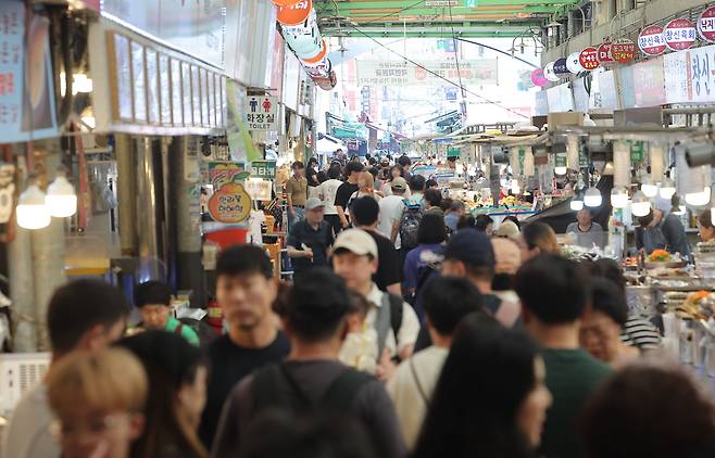 정부가 민생회복 소비쿠폰 1차 지급계획을 발표한 지난 6일 서울의 한 전통시장을 찾은 시민들이 점포를 둘러보고 있다. /연합뉴스