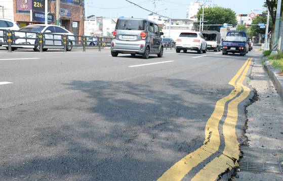 울산 전역에 폭염경보가 내려진 7일 오전 울산 중구 한 주유소 앞 도로가 폭염에 휘어져 있다. 뉴시스