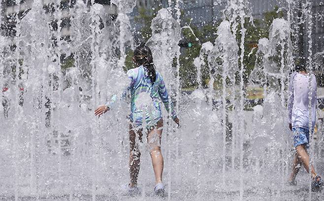 Kids play in water fountains in Gwanghwamun Square in central Seoul on June 19. (Yonhap)