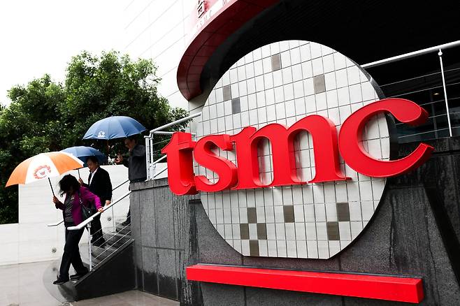 People walk beside TSMC signage outside the company's Museum of Innovation at its headquarters in Hsinchu, northern Taiwan, on Nov. 21, 2024. [AFP/YONHAP]