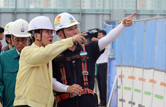 Prime Minister Kim Min-seok, left, inspects a construction site for a national museum in Sejong City on July 7 to prepare for the heat wave. [JOINT PRESS CORPS]
