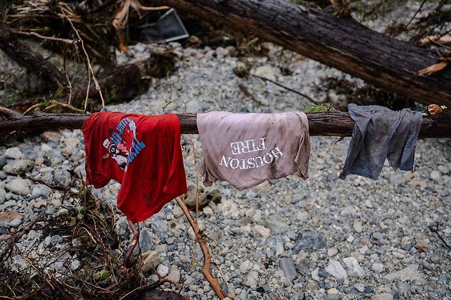 6일(현지시간) 미국 텍사스 주 헌트에 위치한 캠프 미스틱 근처 과달루페 강변의 나무 가지에 어린이 옷이 걸려 있다. [AFP]