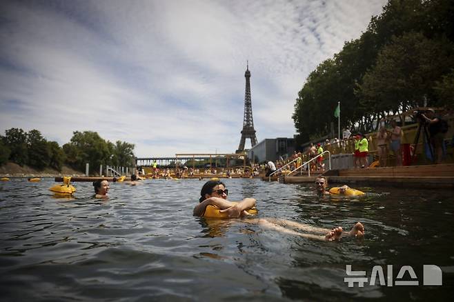 [파리=AP/뉴시스] 5일(현지 시간) 프랑스 파리 센 강에서 시민들이 수영을 하고 있다. 센 강은 100여 년 만에 공공 수영 공간으로 개방됐다. 마리 수로, 베르시 강변, 그르넬 항구 근처 등 세 곳이 야외 수영 구역으로 지정됐으며 오는 8월 31일까지 무료로 개방된다. 탈의실, 샤워 시설, 파라솔, 비치체어 등이 갖춰졌다. 2025.07.07.