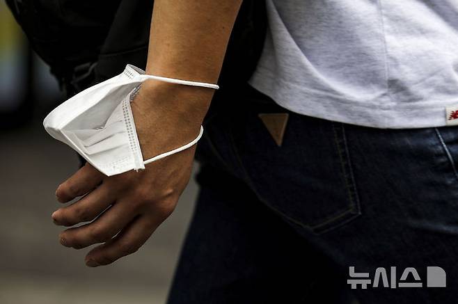 [서울=뉴시스] 정병혁 기자 = 코로나19 재유행으로 인한 환자가 증가하고 있는 가운데 지난해 8월22일 서울 중구 명동거리에서 한 시민이 마스크를 들고 이동하고 있다. 2024.08.22. jhope@newsis.com