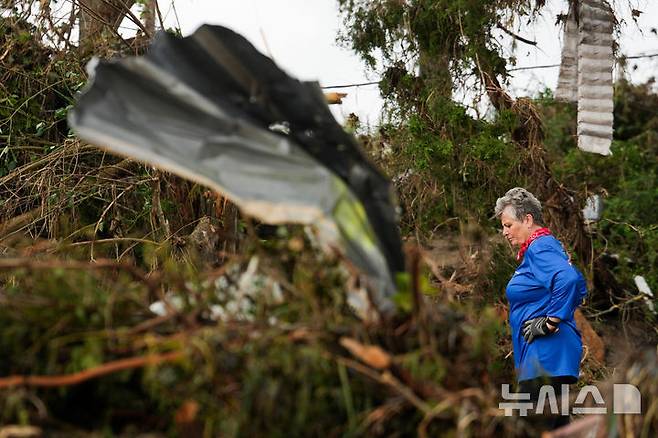 [헌트=AP/뉴시스] 6일(현지 시간) 미 텍사스주 헌트에서 한 여성이 급류성 홍수가 휩쓸고 간 과달루페 강변에서 실종된 조카 남매를 찾고 있다. 텍사스주를 강타한 폭우와 홍수로 지금까지 사망자는 최소 80명, 실종자는 41명으로 늘어났다. 2025.07.07.