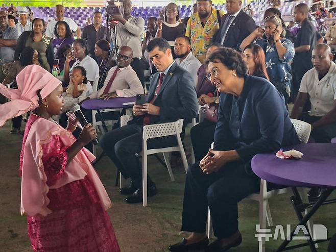 [파라마리보=AP/뉴시스] 6일(현지 시간) 수리남 역사상 첫 여성 대통령으로 선출된  제니퍼 헤얼링스 시몬스 국민민주당 대표가 파라마리보에서 열린 한 파티에서 어린이 노래 공연을 관람하고 있다. 2025.07.07.