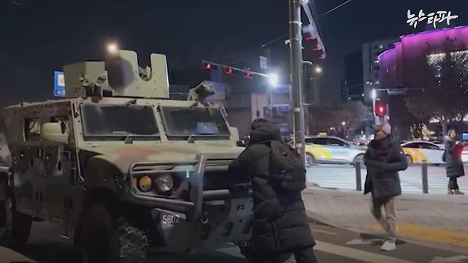 12·3 내란 당시 군용 차량을 시민이 몸으로 막고 있는 모습.&nbsp;