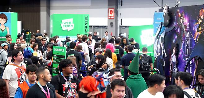 LA 애니메 엑스포 2025의 웹툰 엔터테인먼트 부스에 팬들이 길게 줄을 서서 참여하고 있다. 네이버웹툰 제공
