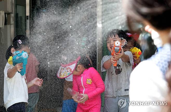 시원한 물총놀이 (광주=연합뉴스) 연일 폭염 특보가 이어지고 있는 7일 광주 북구청직장어린이집 앞마당에서 아이들이 교사와 물총놀이를 하며 더위를 식히고 있다. 2025.7.7 [광주 북구 제공. 재판매 및 DB 금지] in@yna.co.kr
