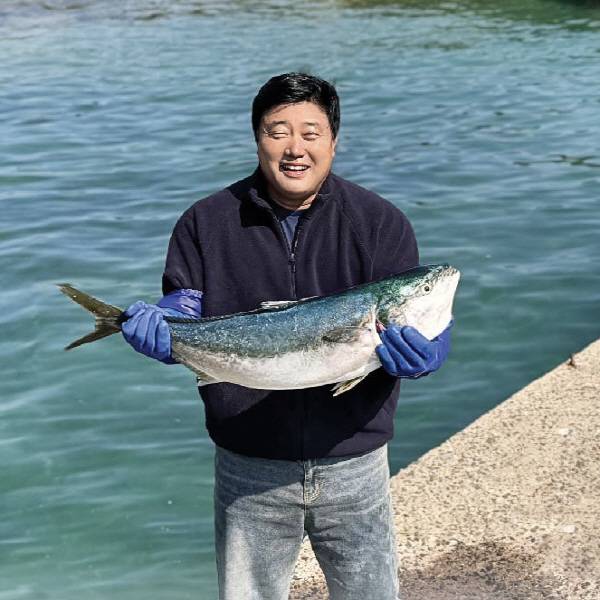 양준혁 대표가 직접 기른 방어를 들고 활짝 웃으며 포즈를 취하고 있다.