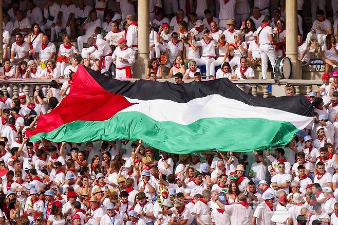 7일(현지시간) 스페인 팜프로나에서 열린 산 페르민 축제에서 투우를 관람하는 사람들이 팔레스타인 국기를 펼치고 있다. ⓒ AFP=뉴스1