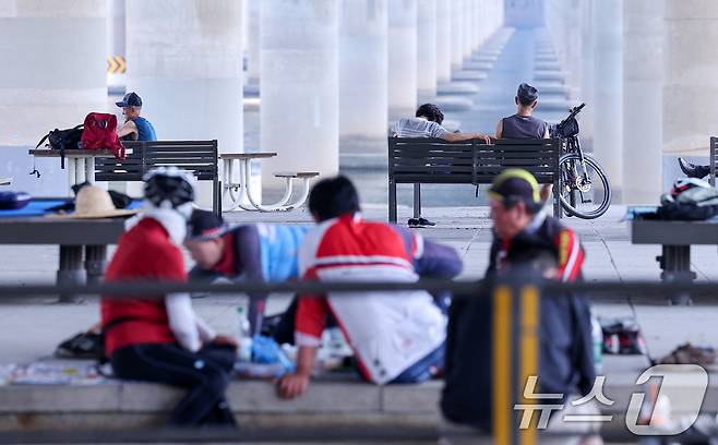 전국 대부분 지역에서 최고 체감온도가 35도 안팎으로 오르며 무더운 날씨가 이어진 8일 서울 영등포구 마포대교 남단 아래 그늘을 찾은 시민들이 무더위를 피하고 있다. 2025.7.8/뉴스1 ⓒ News1 김성진 기자