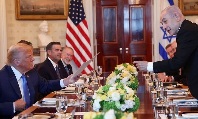 도널드 트럼프 미국 대통령이 7일(현지시각) 워싱턴 D.C. 백악관에서 베냐민 네타냐후 이스라엘 총리와 만찬을 하면서 문서를 받고 있다. 워싱턴/로이터 연합뉴스