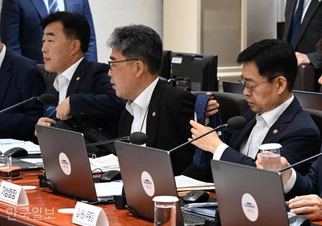 8일 대통령실에서 열린 국무회의에 참석한 배석자들이 복장이 노타이 차림이라는 사실을 뒤늦게 알고 넥타이를 풀고 있다. 왕태석 선임기자