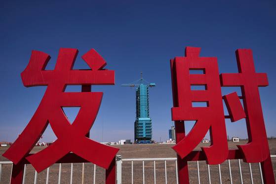 지난 4월 25일 중국 간쑤성 주취안 위성발사센터의 ‘발사’ 표식 뒤로 유인우주선 선저우 20호를 탑재한 창정2F 로켓이 발사 전 마지막 정비를 하고 있다. AP=연합뉴스