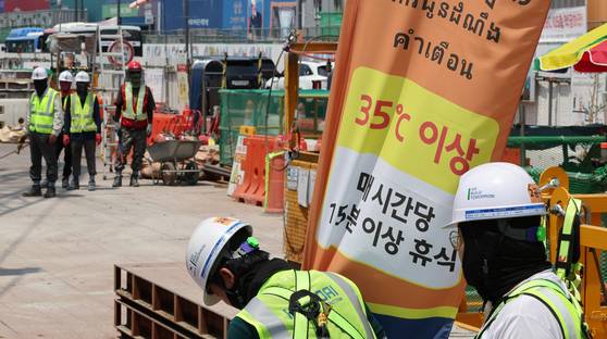 8일 폭염 경보가 발효 중인 서울 강남구 한 공사현장에 '체감온도 경보' 안내문이 설치돼 있다. 관계자는 근로자들이 45분 작업, 15분 휴식을 하고 있다고 밝혔다. 연합뉴스