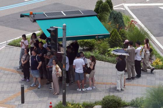 서울 지역에 폭염경보가 발효 중인 8일 서울 중구 을지로1가사거리에서 시민들이 햇볕을 피해 그늘막 아래서 신호를 기다리고 있다. 뉴시스