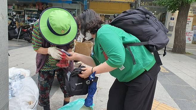 서울시자원봉사단이 폐지 수집 어르신에게 쿨키트를 전달하고 있다. [서울시 제공]
