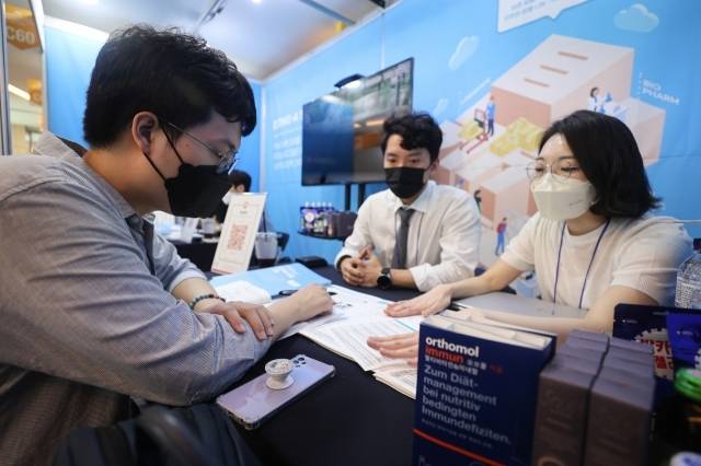 취업박람회 기업 부스에서 상담을 받고 있는 취업준비생 [연합]