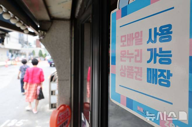 [서울=뉴시스] 권창회 기자 = 경기 부양을 위한 이재명 정부의 첫 민생회복 소비쿠폰이 오는 21일부터 지급된다. 1차로 우선 15만~45만원을 지급하며, 9월 22일부터 소득 상위 10%를 제외한 국민 90%에게 10만원을 추가 지급할 예정이다. 난민 인정자도 받을 수 있으며 대형마트, 명품관, 배달앱 등에서의 사용은 제한된다. 사진은 7일 서울 시내 전통시장 내 지역화폐 결제 가능 매장의 모습. 2025.07.07. kch0523@newsis.com