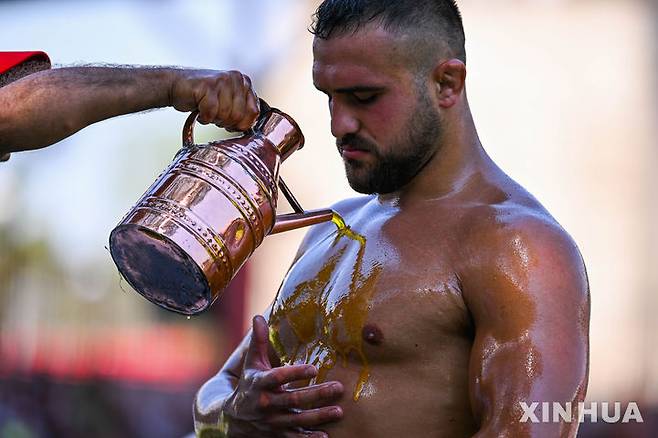 [에디르네=신화/뉴시스] 5일(현지 시간) 튀르키예 에디르네에서 열린 제664회 오일 레슬링 대회에 참가한 참가자가 몸에 올리브 오일을 바르고 있다.대회에 참가한 참가자들은 상의를 벗고 가죽바지만 착용한 채 온몸에 올리브 오일을 발라야 한다. 상대의 등이 바닥에 닿으면 승리한다. 2025.07.07.
