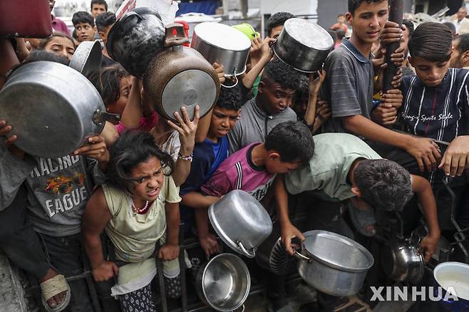 [가자시티=신화/뉴시스]  가자지구 가자시티의 한 급식소에서 4월 24일 무료 급식을 받으려는 팔레스타인 난민들이 몰려들고 있다. 이스라엘군이 가자지구에 대한 식량 등 구호품 반입을 봉쇄한 뒤 가자지구의 인도주의적 참상이 극에 달하자, 유엔이 봉쇄 해제를 적극 요구하고 있다. 유엔 인도주의 업무조정국(OCHA)은 연료마저 떨어져 긴급구호에만 이를 배정하고 있다고  7월7일 밝혔다. 2025.07.08.