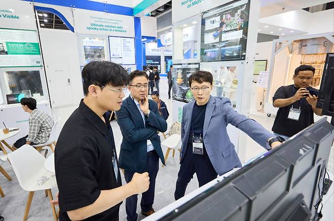 [서울=뉴시스] 퀀텀코리아 2025에서 큐밋의 전선곤 대표가 주용태 경제실장에게 양자이득을 획득하는 논리 시스템 설명. 2025.07.08. (사진=서울시 제공) *재판매 및 DB 금지